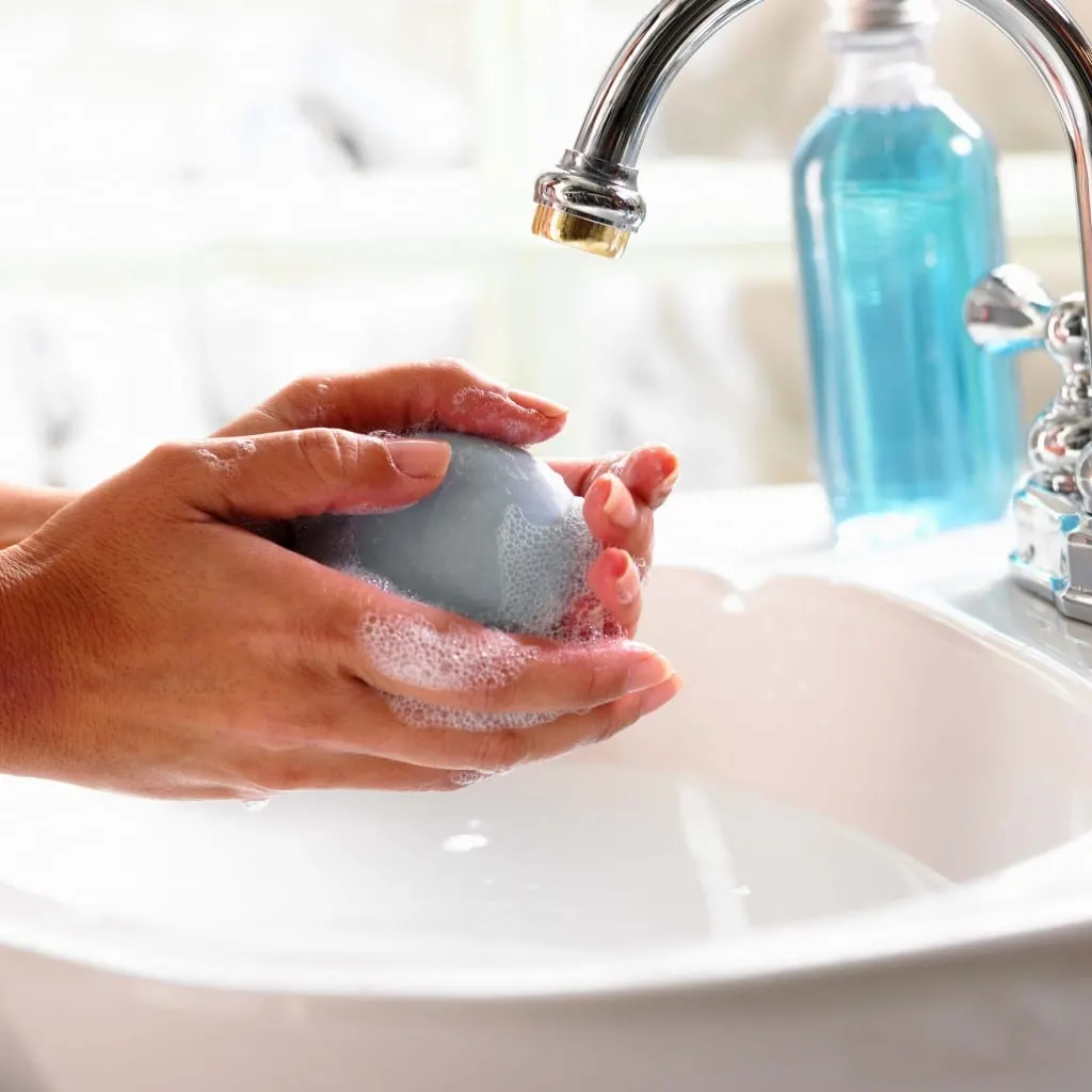 Person washing hands in sink