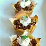 This savory, bite-sized appetizer Taco Cupcakes recipe makes the perfect appetizer for football season or a main dish for any occasion. All the flavors you love from tacos made wrapped in wonton wrappers for an easy to eat appetizer. #tacos #tacocupcakes #tacorecipes #beefrecipes #groundbeefrecipes #kidfriendlyrecipes #appetizers #appetizerrecipes #texmex #cincodemayo #wontonwrappers