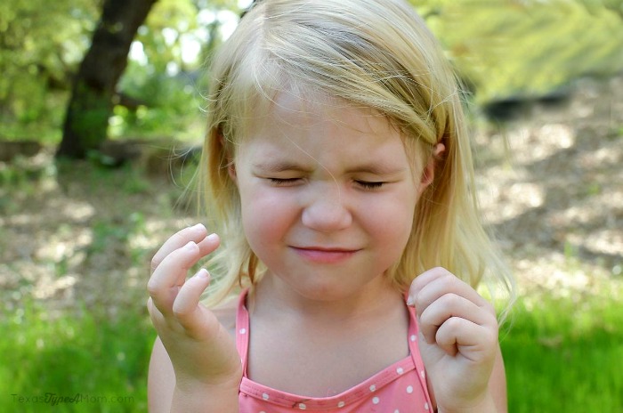Child closing her eyes for sunscreen application