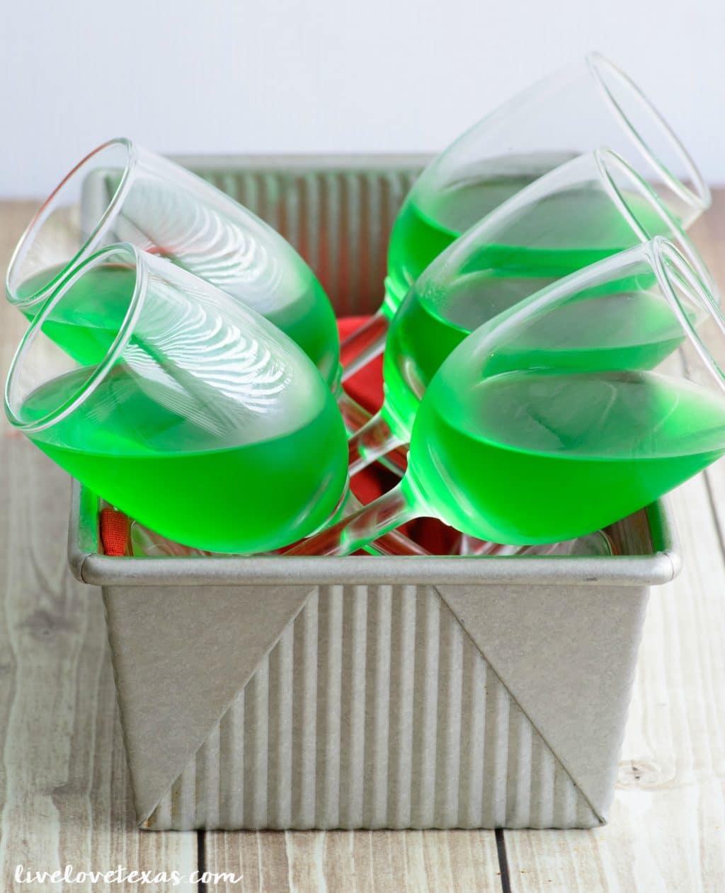 How do you make jello parfait? Lime Jello chilling in fridge at angle in wine glasses.