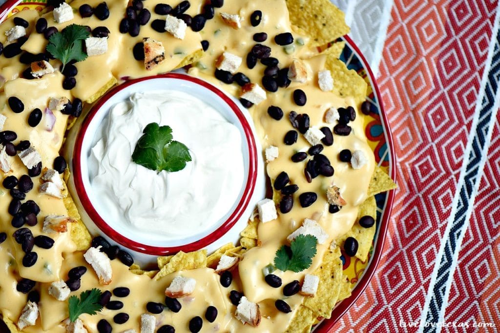 Enjoy nachos at home with a twist. These are the Best Tex Mex Nachos topped with an Easy Homemade Queso Dip Recipe...and without boxed, processed cheese! 