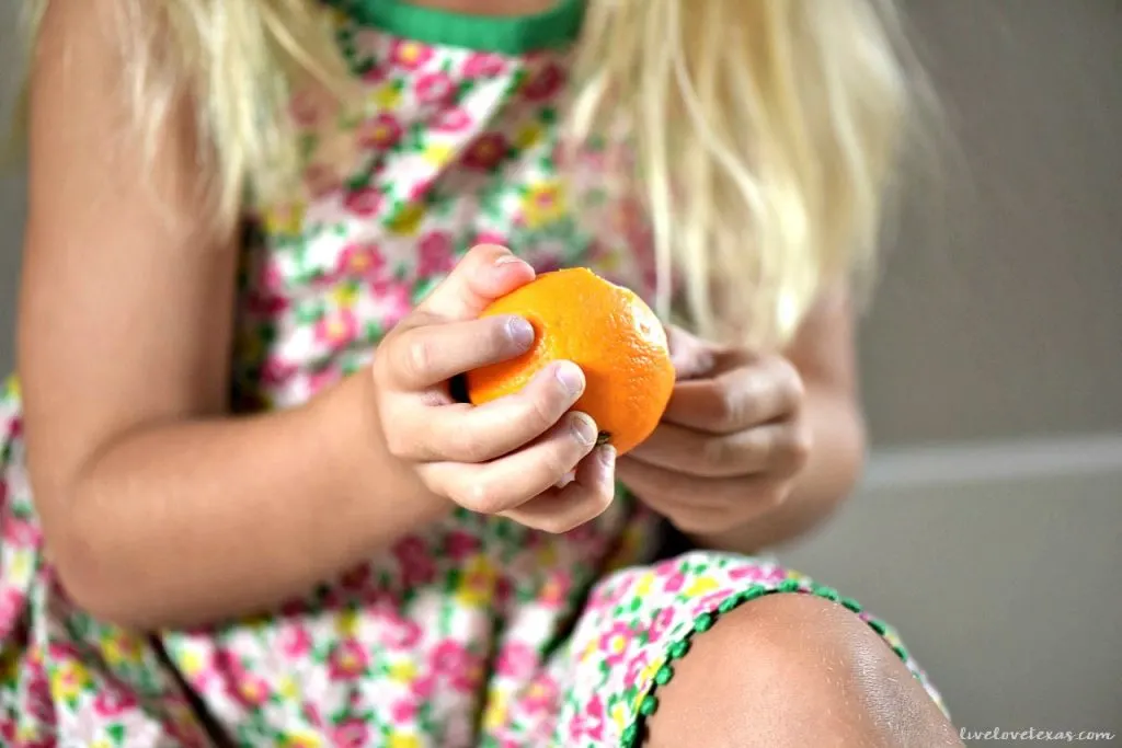 Preschooler peeling clementine