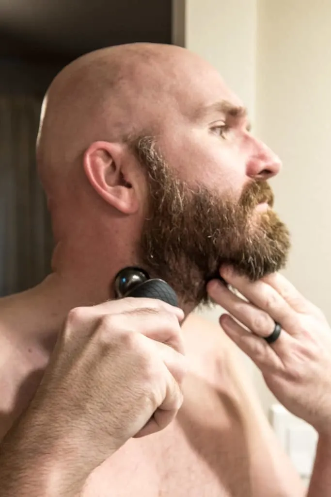 Bald man fading beard with Philips Norelco S9000 electric shaver.
