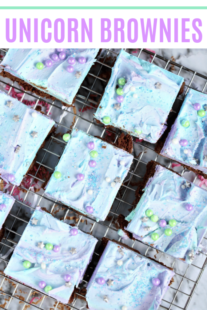 The best homemade unicorn brownies on a baking rack, frosted and with sprinkles.