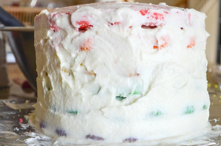 Big rainbow layer cake with crumb cake cake frosting layer.