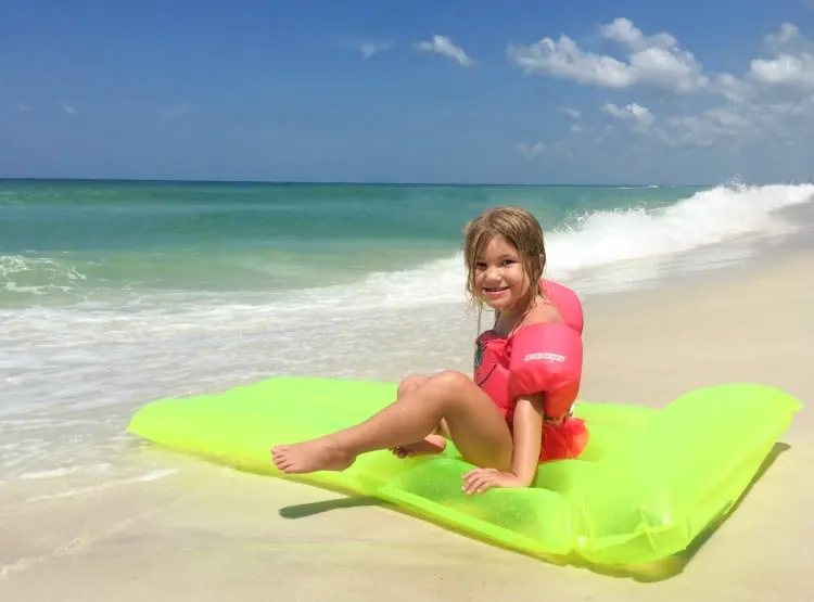 Preschool girl wearing life vest on beach