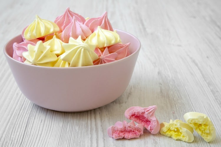 How to make meringue cookies. Pink and yellow meringues in bowl.