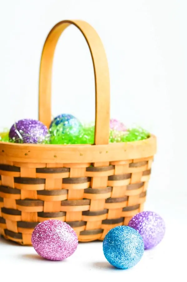Basket of grass with glitter Easter eggs.