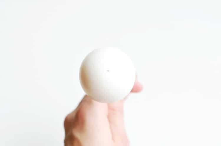 Hand holding blown egg.
