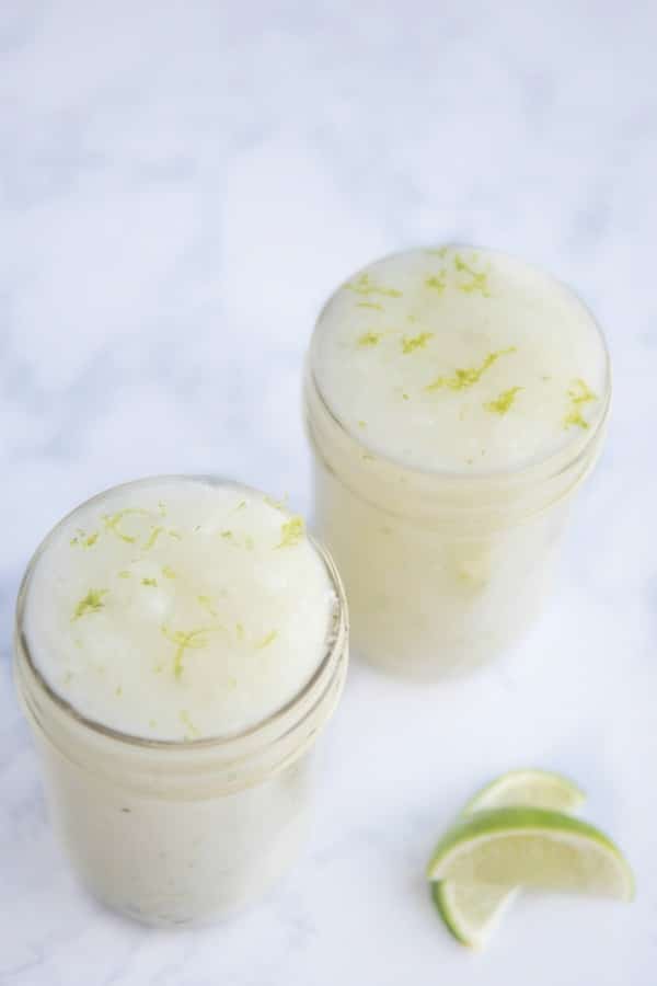 Homemade lime sugar scrub on counter with lime slices.