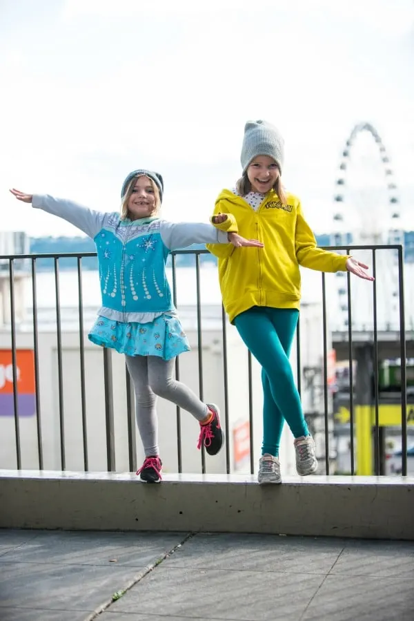 Two girls having fun in front of the Great Wheel in Seattle, Washington.