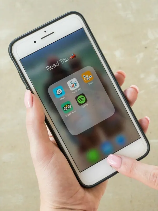 Holding cell phone with the best travel apps folder