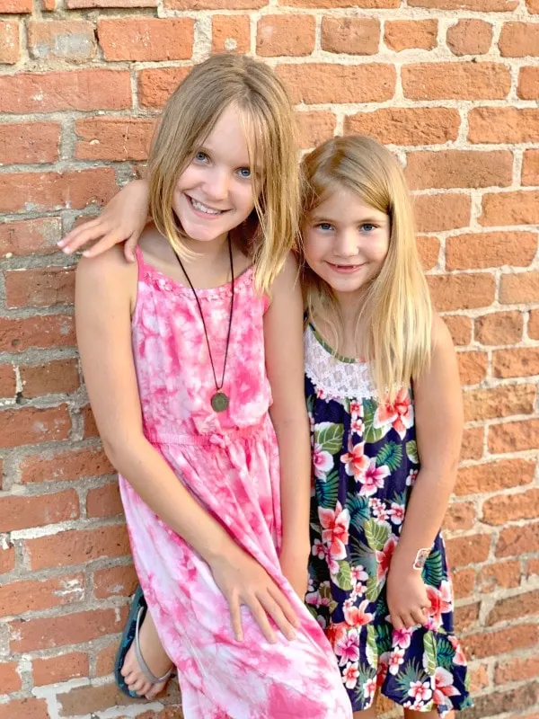 Girls posing next to a brick wall in downtown Bastrop Texas.