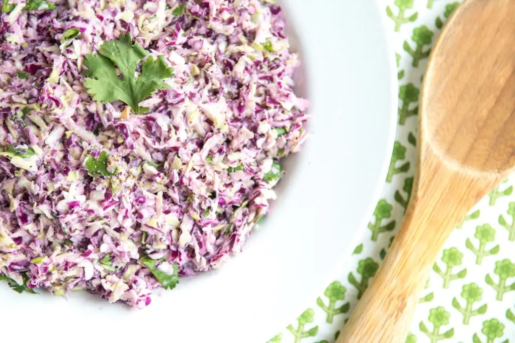 Low Carb Coleslaw in bowl with wooden serving spoon
