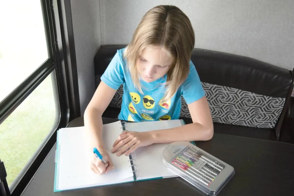 Young girl with ADHD taking notes to brain dump and color coding.