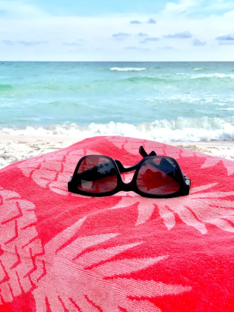 Bose bluetooth sunglasses Wayfarer style on towel at the beach.