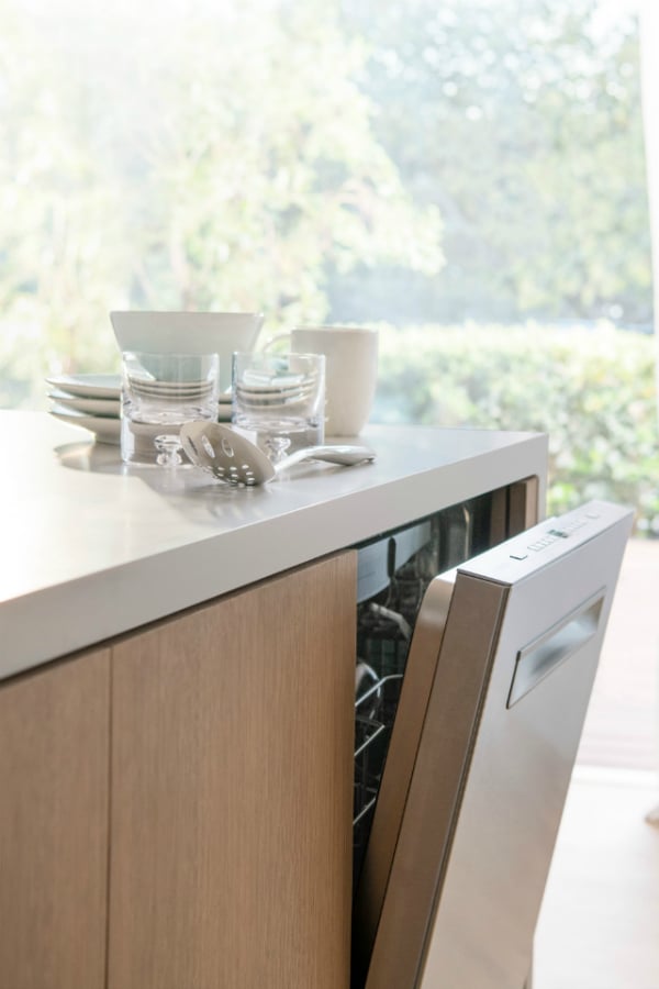 Clean dishes on counter above Bosch dishwasher from Best Buy.