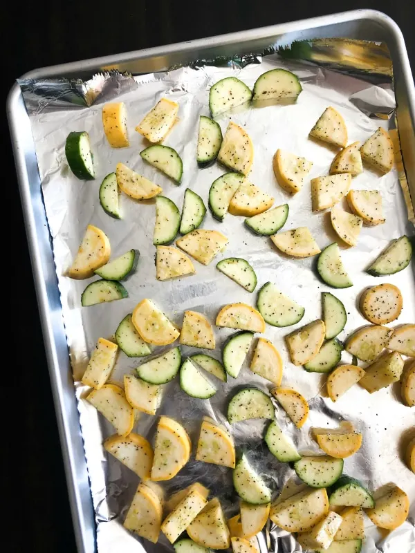Chopped squash and zucchini on sheet pan for roasting