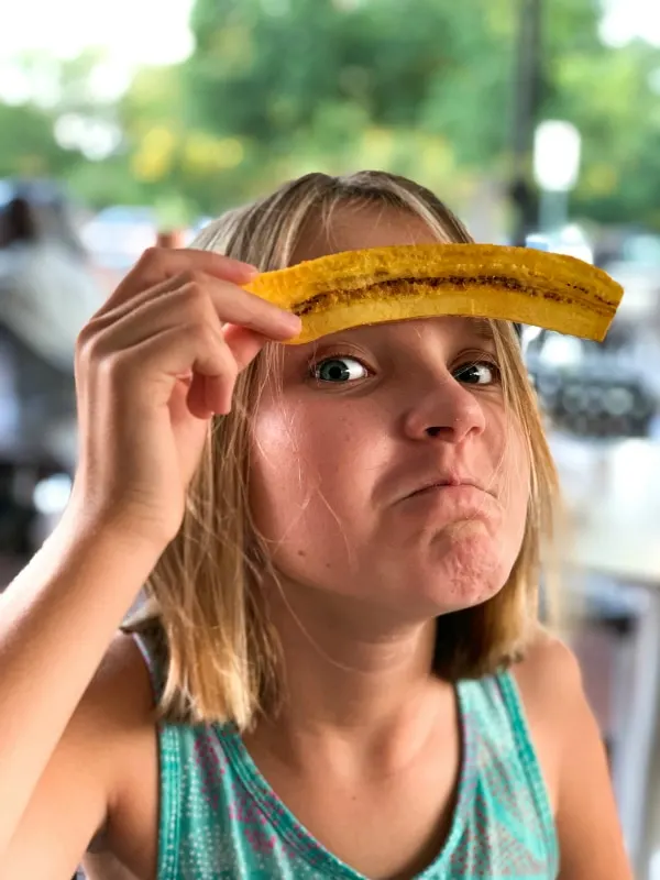 girl posing with plantain eyebrows at restaurant
