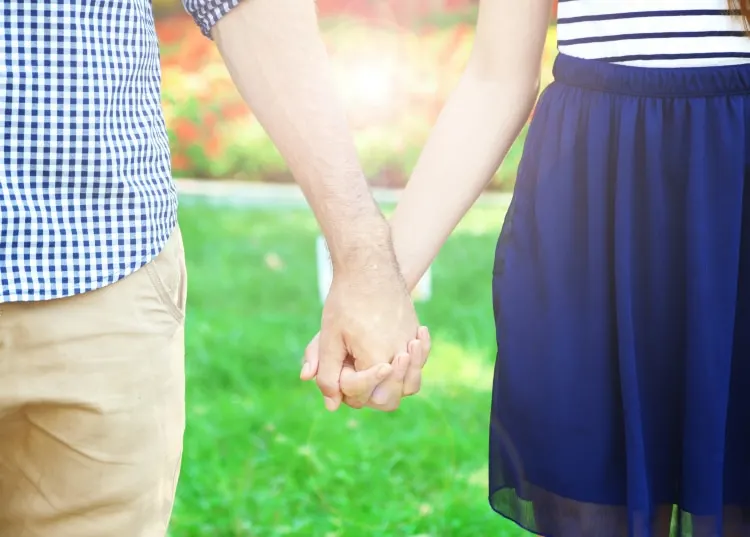 Happy marriage tips: couple holding hands outside.