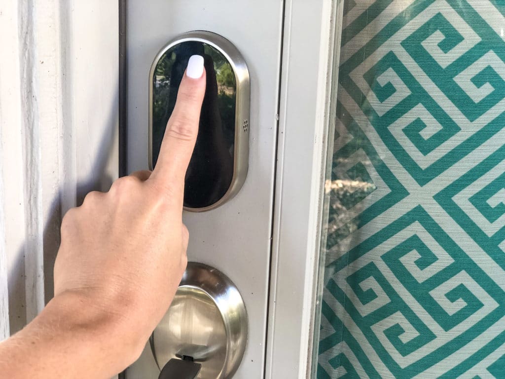 Manicured finger unlocking smart home in Austin Texas.