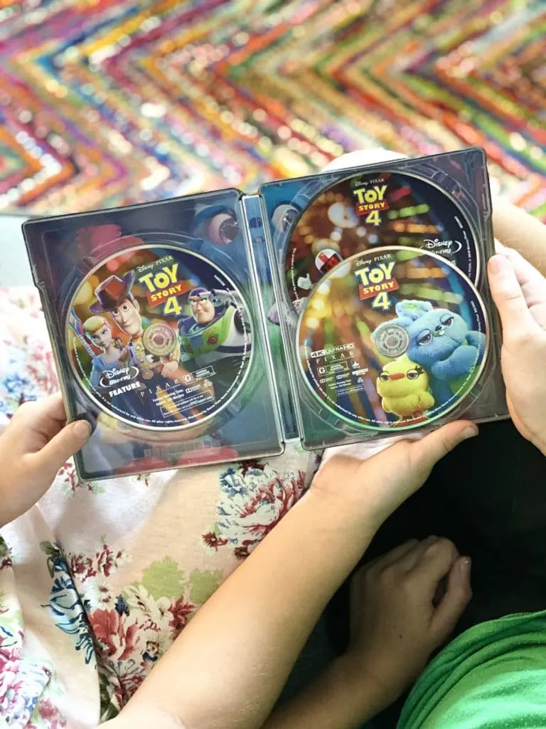 Girls holding Toy Story 4 Steelbook DVD on couch