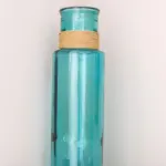 Teal glass jars, candles, and Alex Echo Dot on shelf in living room with sign on how to use Alexa Echo Dot to control lights. Text overlay: Best Smart Home Devices for Vacation.