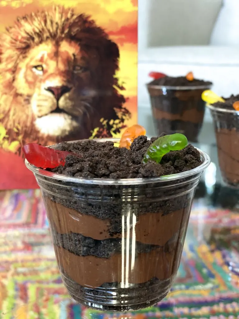 Lion King recipe of Dirt Cups with Gummy Worms on table closeup.