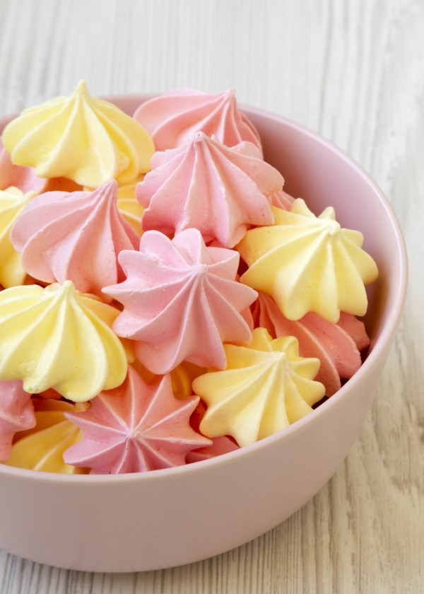 Pink and yellow meringue cookies in bowl