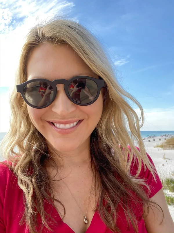 Woman on beach wearing sunglasses for her heart shaped face.