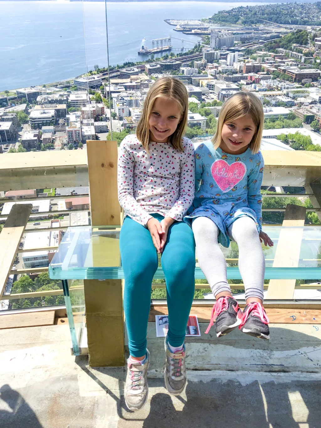Girls sitting on glass benches at the top of the Space Needle