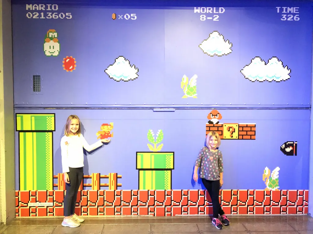 Girls standing in front of Museum of Pop Culture Nintendo wall