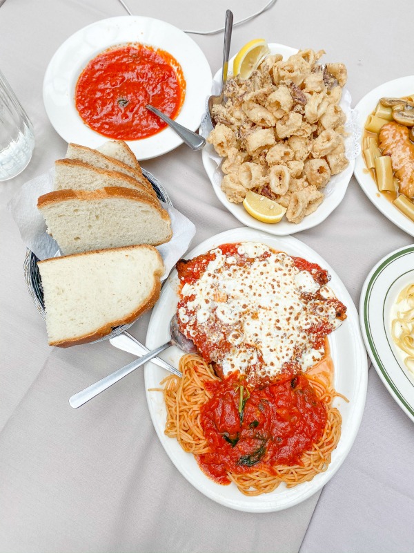 Italian appetizers on table - bread, calamari, chicken parmigiana, marinara