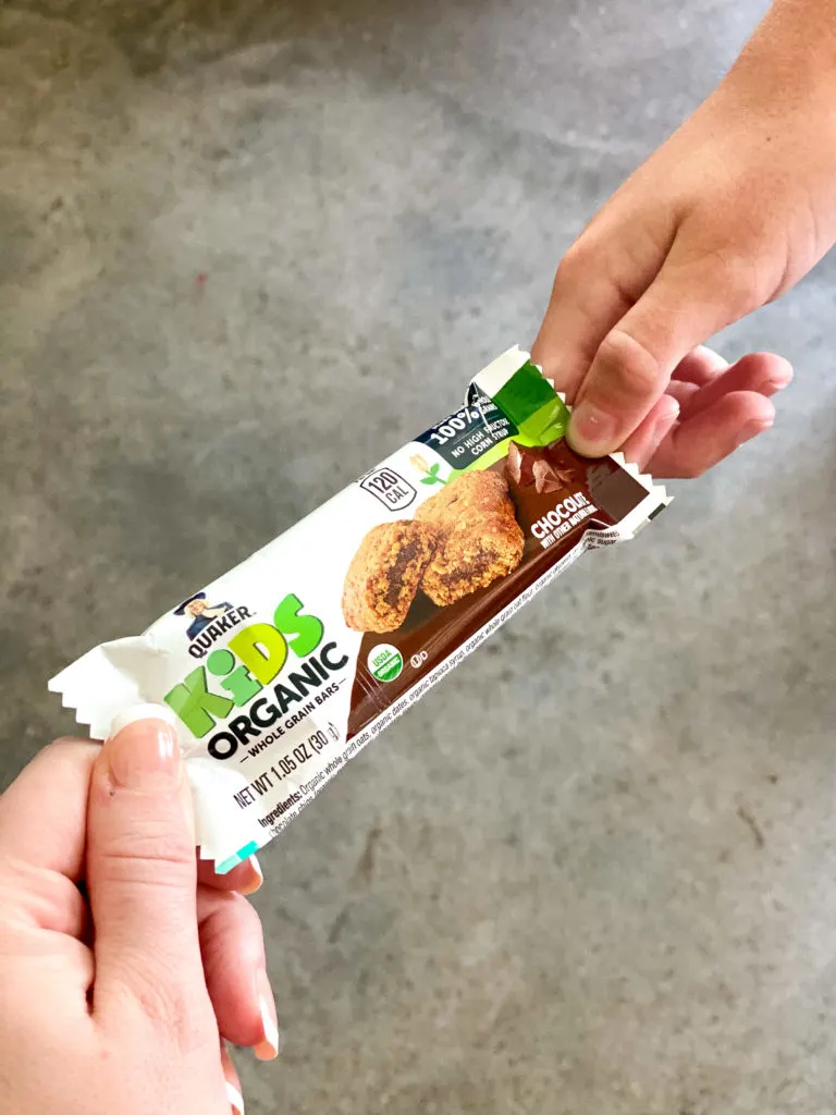 mom giving daughter quaker snack bar for easy snack