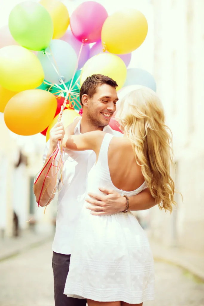 couple before marriage with colorful balloons in the city