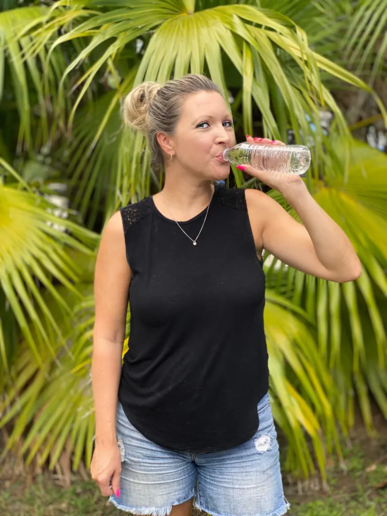 woman drinking water bottle outside